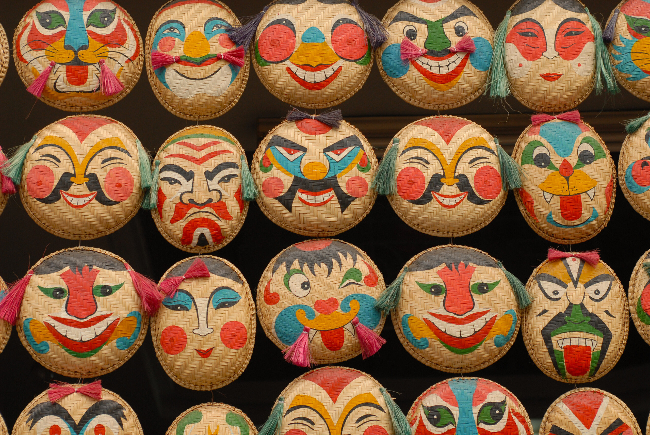 The typical vietnamese face masks with traditional paintings, made of straw at the souvenir market in Hanoi, Vietnam.